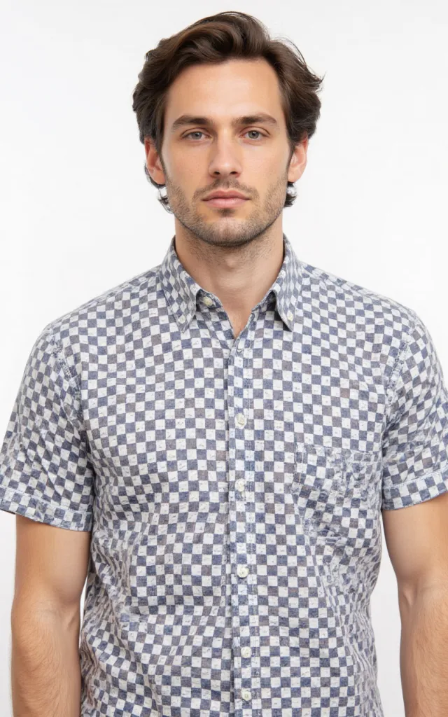 A French model wearing a Checkered pattern   printed shirt, against a white background, in a front   facing bust portrait